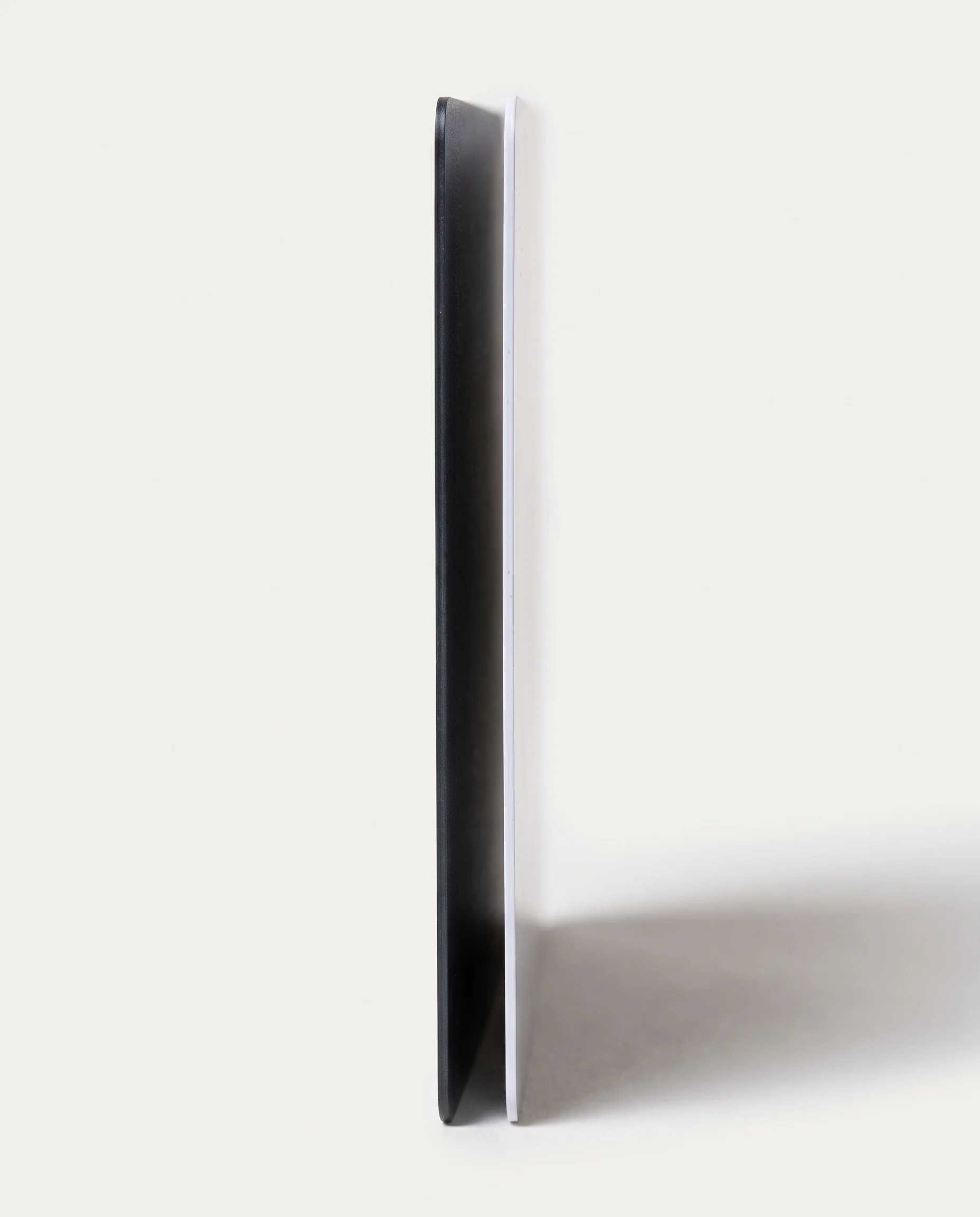 Side view of a graphite card edge beside a blank white card. The graphite card is slightly thicker.